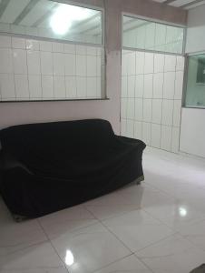 an empty room with a bed on a tiled floor at Renascer in São Pedro da Aldeia +1 photo