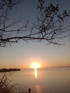 a sunset over a body of water at Renascer in São Pedro da Aldeia