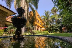 a water fountain in front of a house at Hotel La Mansion del Sol in Guadalajara