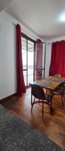 a room with a table and chairs and red curtains at Casa Manzoni in Novara