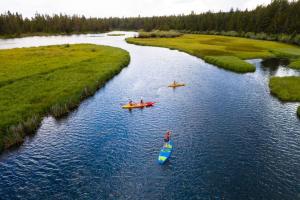 a group of people in kayaks on a river at 61 Meadow House in Sunriver