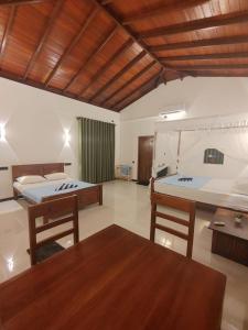 a large room with two beds and a table at Nature Velora Villa in Tangalle
