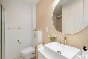 a bathroom with a white sink and a mirror at Baltic Harmony - Easy-Rent Apartments in Pobierowo