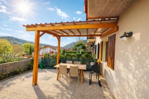a wooden pergola on a patio with a table and chairs at Casa Florian in Vito dʼAsio