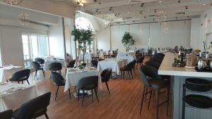 a dining room with white tables and chairs at Taboo Muskoka in Gravenhurst +24 photos