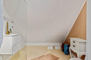 a white room with a staircase with a sink and a mirror at LN2056-Hjorring-Strandvejen-56 in Lønstrup +12 photos