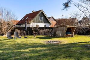 a house with a yard with two chairs in front of it at LN2056-Hjorring-Strandvejen-56 in Lønstrup