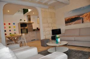 a living room with a couch and a table at Holiday in Arles -Maison du Centre Historique in Arles