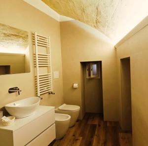 a bathroom with a sink and a toilet at Alma Mater Suite in Matera