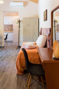 a bedroom with a bed and a desk and a table at Joya's Little Farm Cottage in Svoronata
