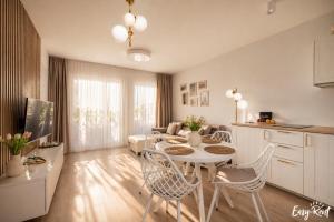 a kitchen and living room with a table and chairs at Baltic Harmony - Easy-Rent Apartments in Pobierowo