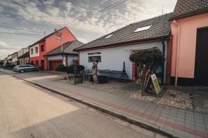 a building with a bench on the side of a street at Penzion U Hada in Velké Pavlovice