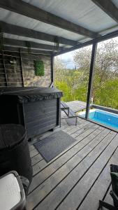 a wooden deck with a swimming pool and a table at Apart Garden з чаном-джакузі in Slavske