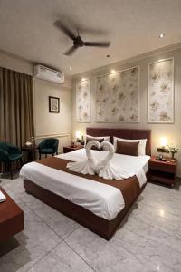 a bedroom with a large bed with a heart shaped pillow at Hotel Maharaja 2 in Udaipur