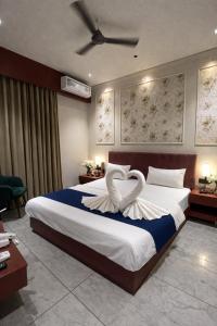a bedroom with a large bed with a heart shaped pillow at Hotel Maharaja 2 in Udaipur