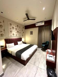 a hotel room with a bed and a ceiling fan at Hotel Maharaja 2 in Udaipur