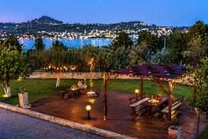 a patio with tables and umbrellas at night at Acqui Apartments in Argostoli +39 photos