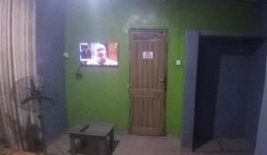 a room with a door and a tv on the wall at JK Hotels in Lagos