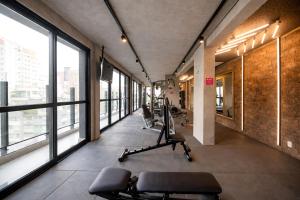 a gym with chairs and windows in a building at Housi On Jardins in São Paulo +262 photos