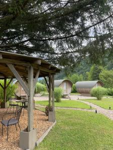 a picnic table and chairs under a pavilion in a yard at 4 Elements Glamping & Apartments in Bled +9 photos