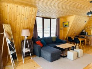 a living room with a blue couch and a table at River View Cabin Kazbegi in Kazbegi