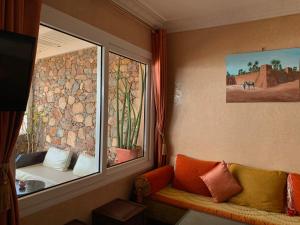 a room with a window with a couch and a window at Appartement terrasse de la mer in Mirleft