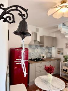 a kitchen with a red refrigerator and a table with a bell at Garden House - InBorgo in Acquasparta