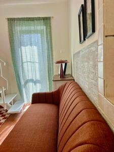 a living room with a couch and a window at Garden House - InBorgo in Acquasparta