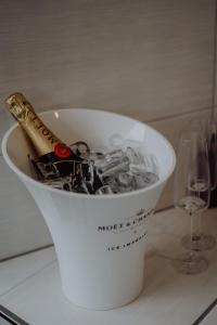 a bottle of wine in a bucket of ice and a glass at Luxus-Apartment Champagner & Spa in Herford