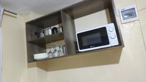 a microwave on a wall in a room at H&Dluxe in Murangʼa