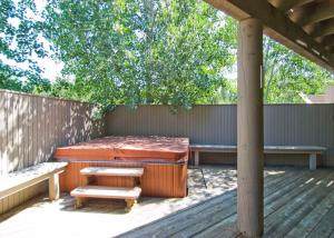 a patio with two beds and a bench on a deck at 6 Summit View Lane in Sunriver +24 photos
