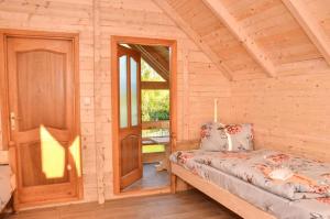 a room with a bed in a wooden cabin at Vidikovac Uvac in Družiniće