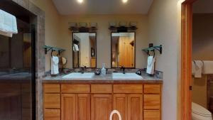 a bathroom with two sinks and two mirrors at 6 Summit View Lane in Sunriver