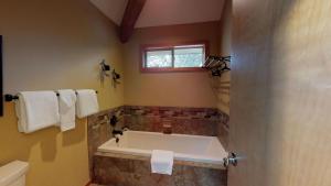 a bathroom with a bath tub and a window at 6 Summit View Lane in Sunriver