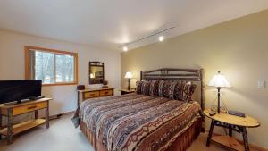 a bedroom with a bed and a flat screen tv at 6 Summit View Lane in Sunriver