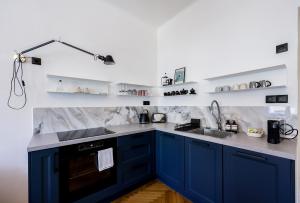 a kitchen with blue cabinets and white walls at Apartmán v srdci Tábora in Tábor