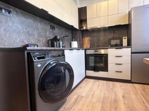 a kitchen with a washing machine in a kitchen at Central Stara Zagora Apartment in Stara Zagora