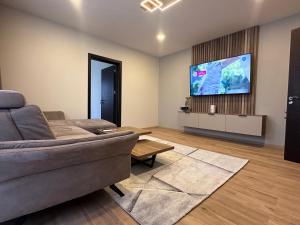 a living room with a couch and a flat screen tv at Central Stara Zagora Apartment in Stara Zagora
