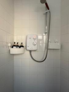 a shower in a white tiled bathroom at Little Gem in Dublin