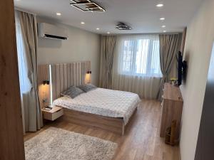 a bedroom with a bed and a large window at Central Stara Zagora Apartment in Stara Zagora