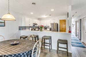a kitchen and dining room with a table and chairs at Oak Island Beachfront Condo w/ Community Pool in Oak Island