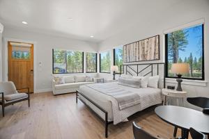 a bedroom with a bed and a couch and windows at 18112-2 Forestbrook Loop in Bend