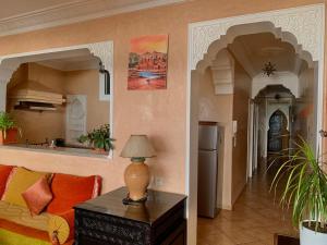 a living room with a couch and a table with a lamp at Appartement terrasse de la mer in Mirleft