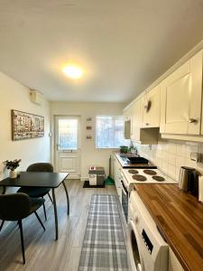 a kitchen with white cabinets and a table and a dining room at Little Gem in Dublin