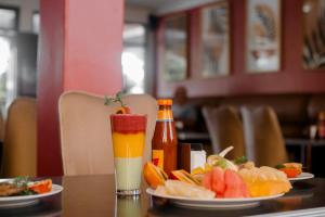 a table with a plate of fruit and a drink at Migano Hotel in Ruhengeri