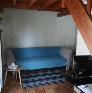 a blue couch in a room with a table at le bien l'authie in Colline-Beaumont