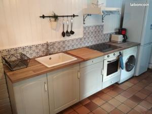 a kitchen with a sink and a washer and dryer at le bien l'authie in Colline-Beaumont