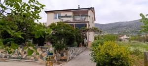 a house with a balcony on a stone wall at Zagrljaj prirode in Blagaj