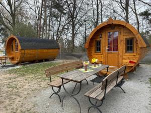 a wooden cabin with a picnic table and benches at Campingfass Zur Adria in Großdubrau