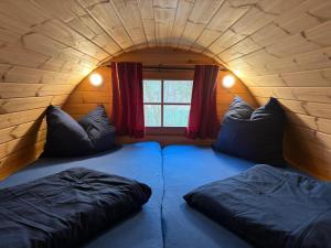 a room with two beds in a room with a window at Campingfass Zur Adria in Großdubrau